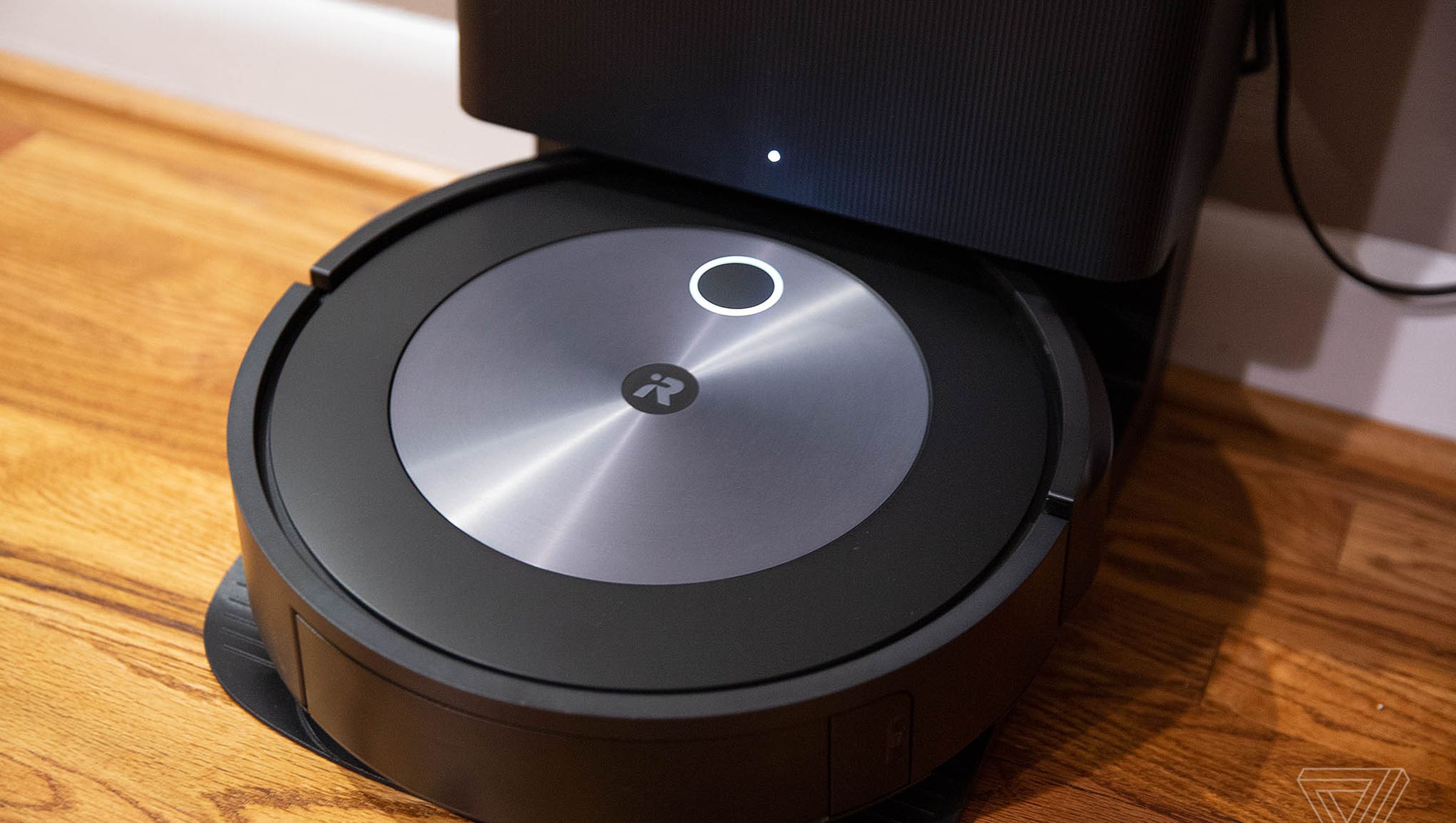The iRobot Roomba j7 stands upright against the wall.