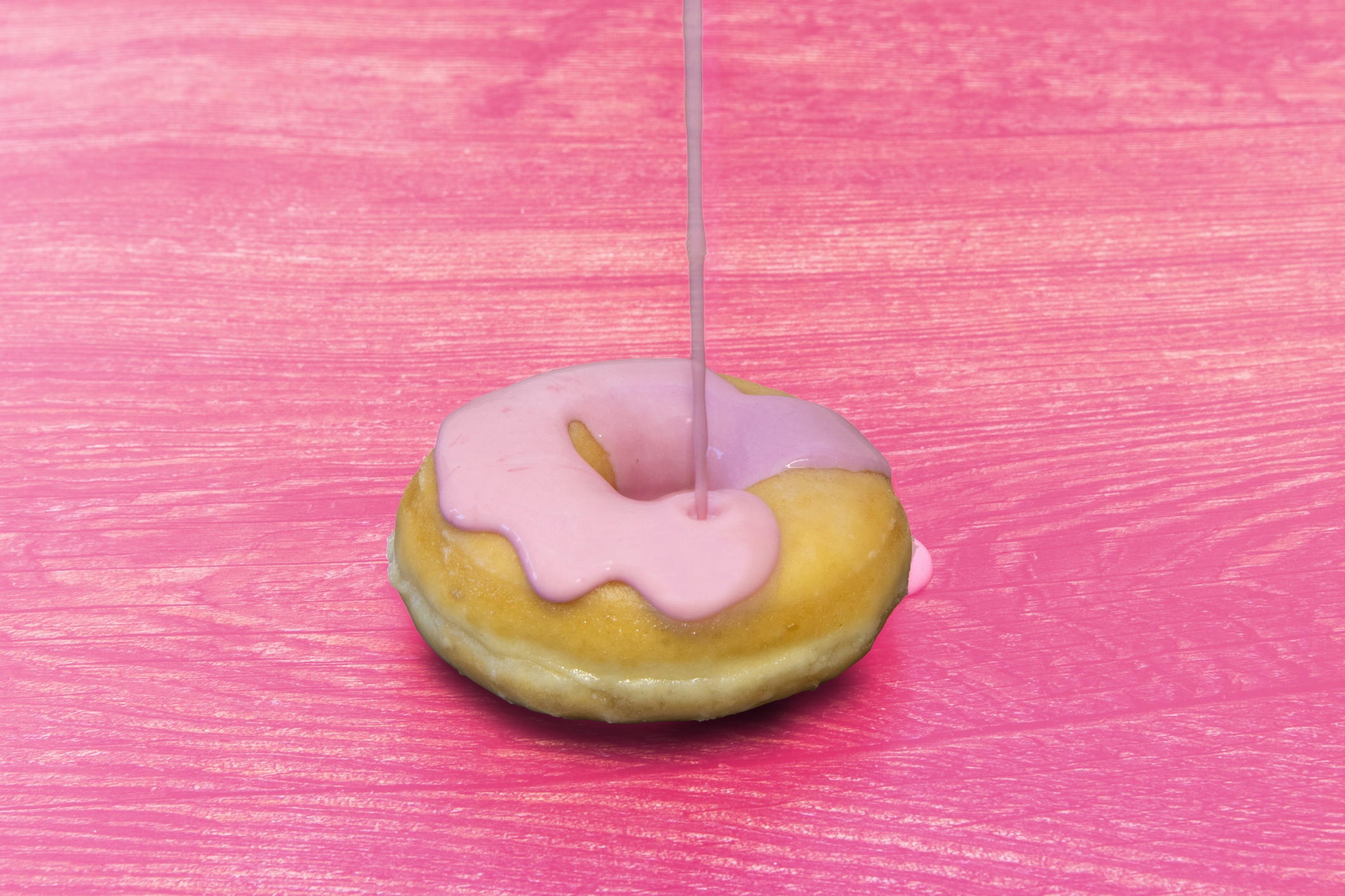 donut with pink toppings on a pink table